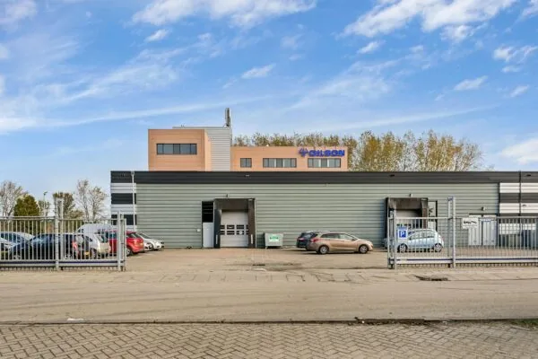 Bedrijfsgebouw van Gilson aan de Laan van ’s-Gravenmade met parkeerplaatsen en laadperrons op de voorgrond.